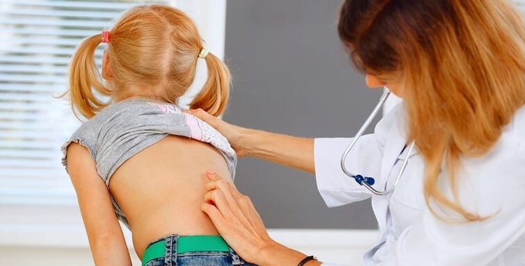 médico examina la espalda de un niño para detectar dolor lumbar